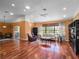 Spacious living room featuring hardwood floors, vaulted ceilings, and large windows at 21815 Tartan St, Leesburg, FL 34748