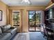 Cozy living room with a desk, large windows, and sliding glass doors to the patio at 21815 Tartan St, Leesburg, FL 34748