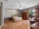 Large bedroom with wood floors, ceiling fan, and sliding glass doors to outdoor patio at 21815 Tartan St, Leesburg, FL 34748