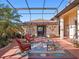 Outdoor patio with comfortable seating, a decorative rug, and lush landscaping at 21815 Tartan St, Leesburg, FL 34748