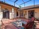 Enclosed patio with decorative tiled trim, patterned concrete flooring, and comfortable wicker furniture at 21815 Tartan St, Leesburg, FL 34748