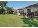 A spacious backyard featuring lush lawn, mature landscaping, and an enclosed patio area for outdoor enjoyment at 236 Juniper Way, Tavares, FL 32778