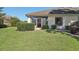 Well-maintained backyard with green lawn, manicured shrubs, and a view of the home's exterior, creating a private oasis at 236 Juniper Way, Tavares, FL 32778