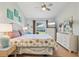 Comfortable bedroom with white dresser, TV, ceiling fan, and beach-themed decor at 236 Juniper Way, Tavares, FL 32778