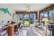 Bright den with large windows, ceiling fan, desk, and a comfortable seating area, perfect for relaxation or work at 236 Juniper Way, Tavares, FL 32778