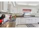 Bright kitchen with granite countertops, white cabinets, and modern appliances creating a clean and functional cooking environment at 236 Juniper Way, Tavares, FL 32778