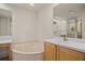 Bathroom featuring a soaking tub, dual vanities, and ample counter space at 26207 Avenida Las Colinas # 26207, Howey In The Hills, FL 34737