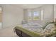 Well-lit bedroom featuring a comfortable bed, neutral carpet, and a cozy wicker chair at 26207 Avenida Las Colinas # 26207, Howey In The Hills, FL 34737