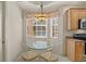 Cozy breakfast nook features a glass table, four chairs, and bright natural light at 26207 Avenida Las Colinas # 26207, Howey In The Hills, FL 34737
