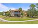 Exterior view with screened balcony overlooking lush landscaping and walkway at 26207 Avenida Las Colinas # 26207, Howey In The Hills, FL 34737