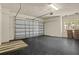 Clean garage with black flooring, newly installed door and side window providing natural light at 26207 Avenida Las Colinas # 26207, Howey In The Hills, FL 34737