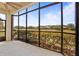 Relaxing screened lanai with a ceiling fan offers panoramic views of the lush green golf course at 26207 Avenida Las Colinas # 26207, Howey In The Hills, FL 34737