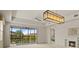 Bright and airy living room with modern lighting, neutral walls, and a sliding glass door to the lanai at 26207 Avenida Las Colinas # 26207, Howey In The Hills, FL 34737