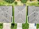 Aerial view of three residences showcasing roof designs, driveways, landscaping, and proximity to each other at 26951 White Plains Way, Leesburg, FL 34748