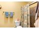 Bathroom featuring a shower with glass door, beach themed shower curtain, and tiled walls at 26951 White Plains Way, Leesburg, FL 34748