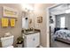 Cozy bathroom featuring granite countertop, framed mirror, and charming decorative accents near the bedroom at 26951 White Plains Way, Leesburg, FL 34748
