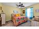 Bright bedroom with floral bedding, soft lighting, and ample natural light creating a cozy retreat at 26951 White Plains Way, Leesburg, FL 34748