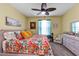 Bedroom with floral bedding, soft lighting, and neutral walls creating a peaceful and inviting atmosphere at 26951 White Plains Way, Leesburg, FL 34748