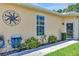 Charming home exterior featuring a well-manicured lawn, decorative sun ornament, and a tidy sidewalk at 26951 White Plains Way, Leesburg, FL 34748