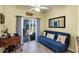 Sitting area with desk, futon, mirror, and curtains leading to patio providing additional living space at 26951 White Plains Way, Leesburg, FL 34748