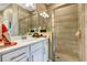 Modern bathroom with tiled shower, quartz counter, and large mirror at 27018 White Plains Way, Leesburg, FL 34748