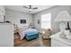 Bright bedroom with white furniture, wood floors, and a comfortable chair at 27018 White Plains Way, Leesburg, FL 34748