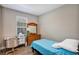 Bedroom featuring a desk, dresser, and bed with a blue quilt at 27018 White Plains Way, Leesburg, FL 34748