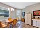 Bright dining area featuring wood floors, a stylish light fixture, and a charming rug at 27018 White Plains Way, Leesburg, FL 34748