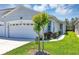 Well maintained home with landscaped yard and manicured lawn with fresh green grass and healthy plants at 27018 White Plains Way, Leesburg, FL 34748