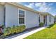 A bright walkway leads to a charming home entrance, framed by lush landscaping and a cheerful exterior at 27018 White Plains Way, Leesburg, FL 34748