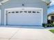 A pristine white garage door with decorative windows complements the manicured landscaping at 27018 White Plains Way, Leesburg, FL 34748