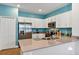 Contemporary kitchen with stainless steel appliances, white cabinets and blue accent wall at 27018 White Plains Way, Leesburg, FL 34748