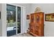 Living room with decorative wood cabinet and screened-in patio view at 27018 White Plains Way, Leesburg, FL 34748