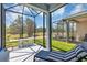 Screened lanai featuring a lounge chair and dining table with a scenic view of the golf course at 27018 White Plains Way, Leesburg, FL 34748