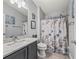 Bright bathroom features a shower with a themed curtain, a vanity, and ample lighting at 2729 Craven Way, The Villages, FL 32162