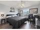 Comfortable bedroom with a ceiling fan, desk, decorative bicycle, and natural light from the window at 2729 Craven Way, The Villages, FL 32162