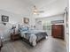 Bedroom with wood look floors, ceiling fan, and dresser and night stands at 2729 Craven Way, The Villages, FL 32162