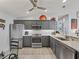 Kitchen with granite countertops, stainless steel appliances, and gray cabinets at 2729 Craven Way, The Villages, FL 32162