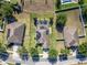 Bird's-eye view of a house with a screened pool, solar panels, in a neighborhood with mature trees and green lawns at 274 Giovani Blvd, Clermont, FL 34715