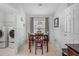 Bright dining area with tile floors, a wooden table set, and a view towards the laundry room at 274 Giovani Blvd, Clermont, FL 34715