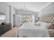 This is a spacious main bedroom featuring a large window, chandelier, and neutral decor and carpet at 274 Giovani Blvd, Clermont, FL 34715
