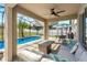 Covered patio with outdoor seating area and a view of the screened-in pool at 274 Giovani Blvd, Clermont, FL 34715