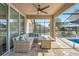 Relax on a patio with an outdoor lounge area, shaded by the screened enclosure and trees at 274 Giovani Blvd, Clermont, FL 34715