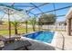 A screened-in backyard pool with an umbrella and lounge chairs at 274 Giovani Blvd, Clermont, FL 34715