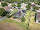 Aerial shot of a screened pool and solar panels, set in a verdant lawn with mature landscaping at 274 Giovani Blvd, Clermont, FL 34715
