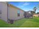 Spacious backyard with lush green grass and a screened lanai, perfect for outdoor entertaining at 287 Ellenton Run, The Villages, FL 32162
