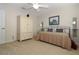 Bedroom features neutral paint, an armoire, and metal bed frame at 287 Ellenton Run, The Villages, FL 32162