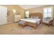 Cozy bedroom boasts a unique woven bed frame, neutral paint, and natural lighting at 287 Ellenton Run, The Villages, FL 32162