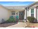 Inviting front porch with seating area and neatly landscaped garden, offering a welcoming entry to the home at 287 Ellenton Run, The Villages, FL 32162