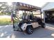 Upgraded golf cart parked outside the garage, featuring custom wheels and comfortable seating at 287 Ellenton Run, The Villages, FL 32162